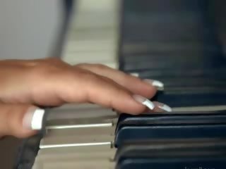 Gros seins blondie jouant abricot sur la piano